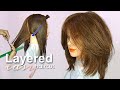 Layered haircut with long curtain bangs