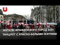 Жители французского город Бон танцуют с красно-белыми зонтами