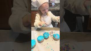 Izabit.  Frosting and adding sprinkles to the cupcakes she helped make.  12-2025