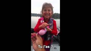 Une petite fille attrape un poisson avec sa canne à pêche barbie