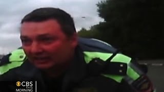 Watch Russian Police Officer Clings To Hood Of Car