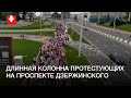 Длинный поток людей на проспекте Дзержинского днем 30 августа