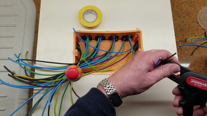 Cables Eléctricos De Colores Que Salen De Una Caja De Empalmes Abierta,  Durante La Renovación De Un Apartamento. Cables Eléctricos Que Salen De  Tubos Corrugados Dentro De La Caja De Empalmes Colocada