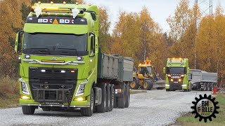 Volvo L90H and Volvo FH , Scania R590 V8 trucks spreading gravel on a road