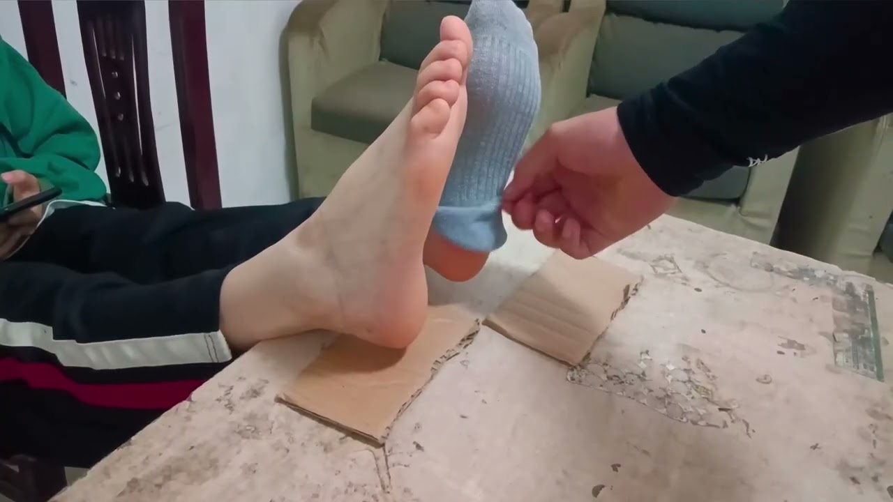 Help a girl take off her shoes and socks