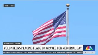 Volunteers place American flags on graves for Memorial Day