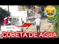 TIRANDOLE CUBETA DE AGUA ALA PERSONA EN LA CALLE