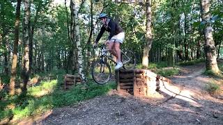 BMX rider goes up ramp near dirt trail then faceplants