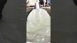 Stirring white pulp mixture in wooden paper-making mold