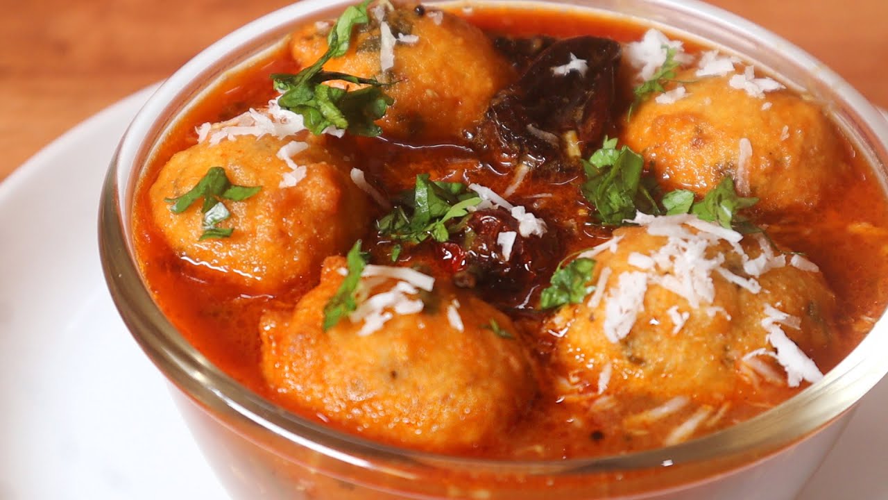 Medu vada soaked in spicy, tangy rasam served with coconut chutney