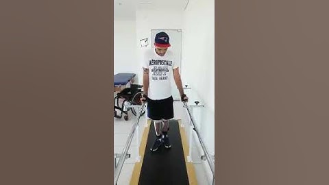 A Paraplegic Man Is Practicing To Walk Holding Parallel Bars.