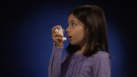 Using a metered dose inhaler one to two inches from mouth