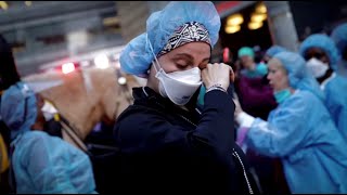 Nurse wipes away her tears as NYPD applaud frontline healthcare workers