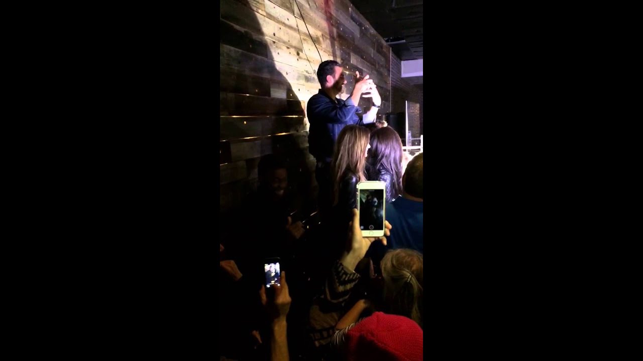 Nyle DiMarco addresses crowd (on the podium)