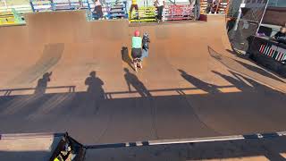 Girl on roller skates drops into half pipe at skatepark and crashes into kid on skateboard