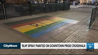 The letters BLM spray painted over the pride crosswalk