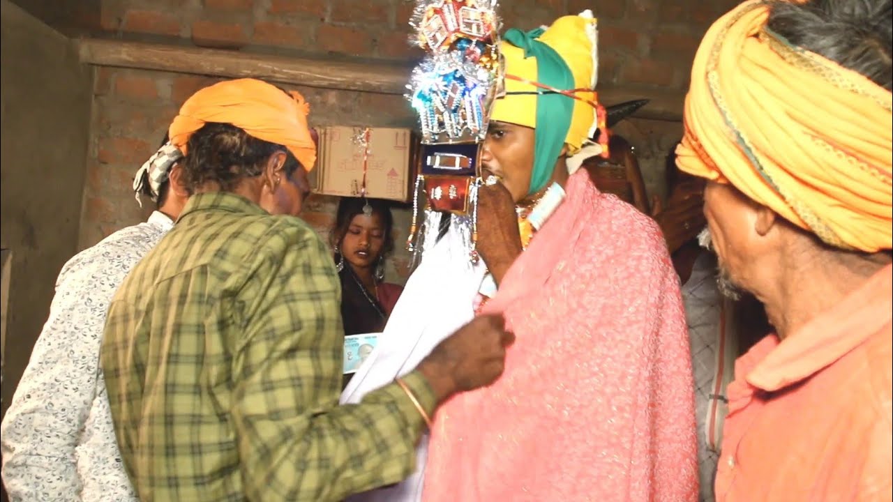 Aadivasi riti riwaj mein Lada ko pagdi bandh rahe hain aadivasi ki