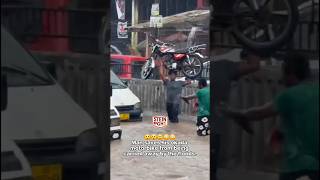Man carries a motorcycle to prevent it from being taken away by flood.