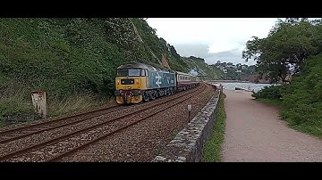 Class A4 60007 Sir Nigel Gresley steam train passing along Teignmouth sea wall with whistle
