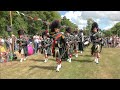 Lonach Pipe Band march on to start displays during 2023 Drumtochty Highland Games in Scotland