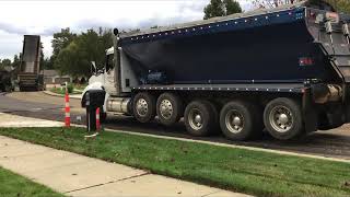 T880 Flowboy truck unloads into a CAT paver