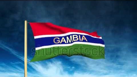 Gambia flag slider style with title. Waving in the wind with cloud background animation Stock video