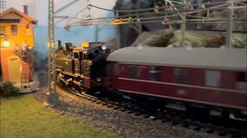 Layout of a small maerklin model railway landscape at night with small steam locomotive scale h0