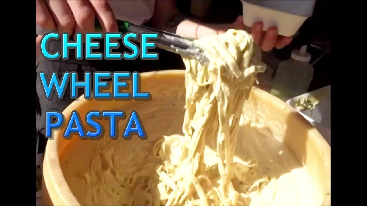 CHEESE WHEEL PASTA, PASTA MADE IN A PARMESAN CHEESE WHEEL IN FRONT OF