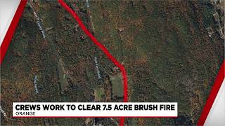 Orange first responders work to clear brush fire