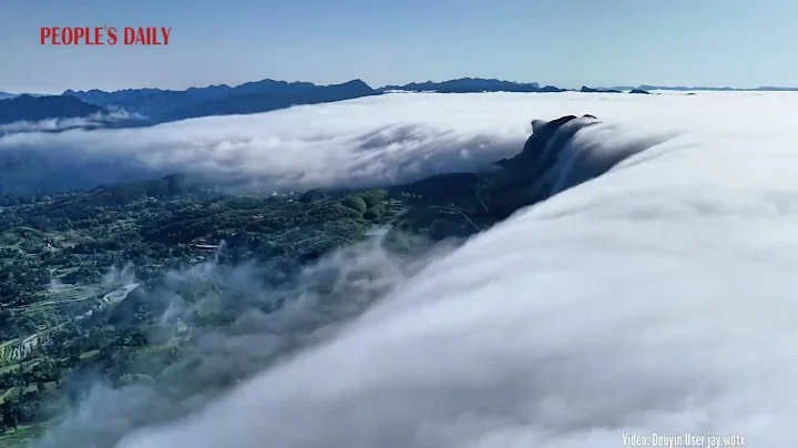 Waterfall of clouds rolling over lush green peaks like water flowing from the sky! - DayDayNews