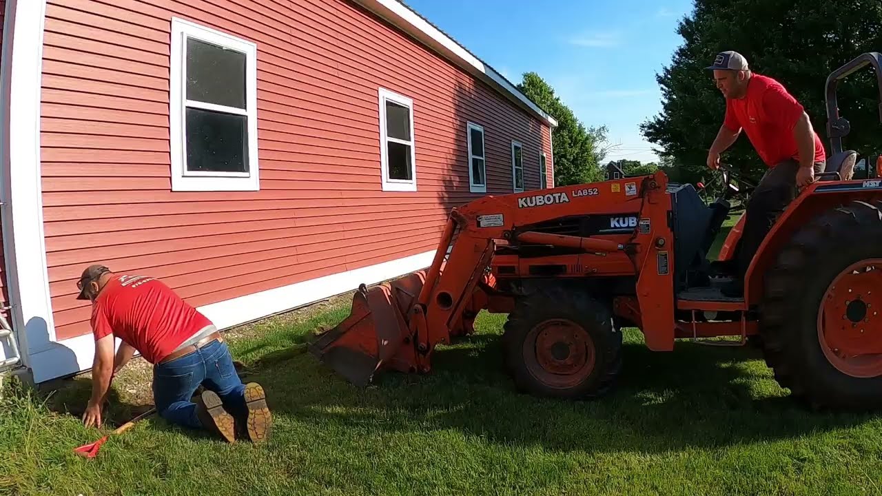 Installing a new foundation drip edge around a house and barn with aluminum landscape edging