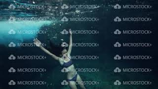 A Young Skinny Woman In Bikini Floating Underwater And Holding Her Breath.