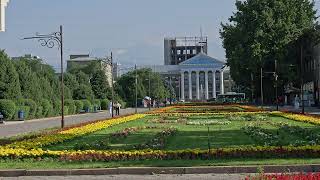 Flowerbed in pedestrian alley with Ala-Too mountains and City Hall in the background in Bishkek