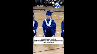 Boy's bored reactions steal the show at kindergarten graduation