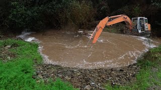 digger clears blocked culvert to save road during 100 year nelson flood