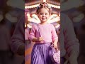 Realistic Toddler Girl Fashion Model in Lavender Outfit, Floral Updo, and Fairground Background