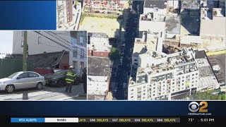 Several cars damaged by partial building collapse in Queens