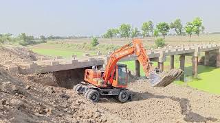 My excavator working with inverted backet to open pull roof for the passage of water