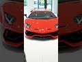 Lamborghini Aventador parked front view, matching glossy red smart key in hand, hand holding key