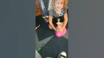 Lil girl trying to pop a balloon with a nude doll