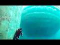 Underwater Camera Captures Massive Shape Passing Below Divers