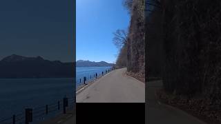 This narrow road was carved between a cliff and a lake.