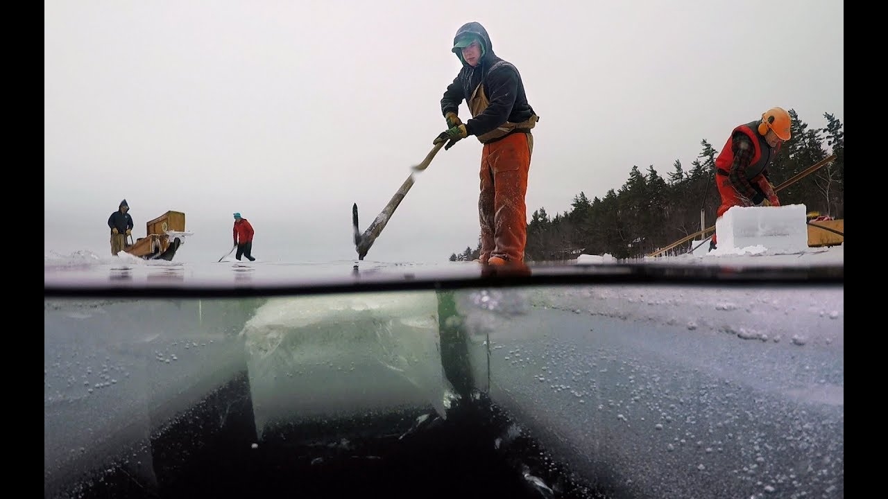 Workers cutting ice blocks on a canal
