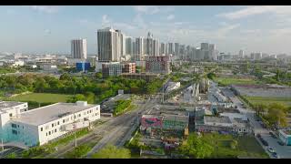 Aerial panoramic view of large city. Vehicles driving on road and crossing railway track. High rise
