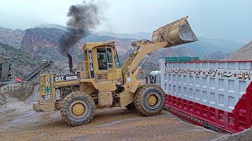 Caterpillar wheel loader 950B loading Big truck with raw material