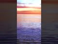 Sunset sky reflected in calm waves in slow motion