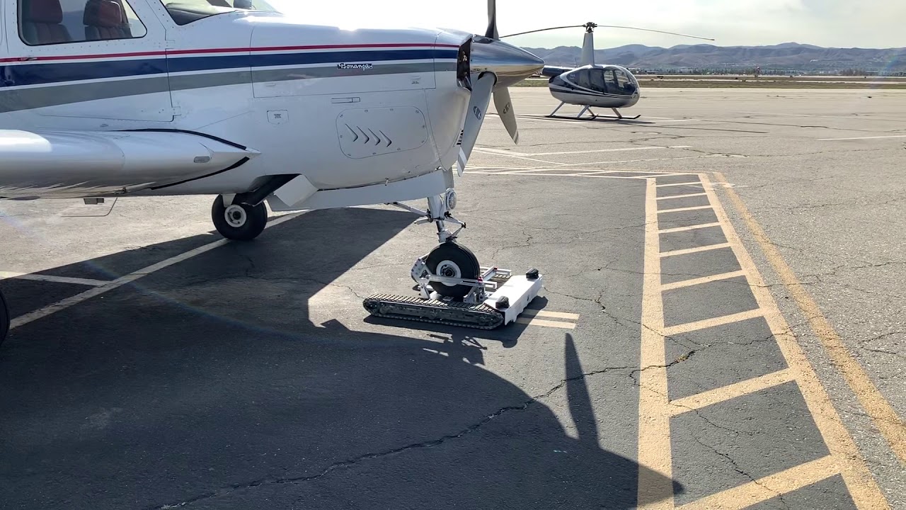 Unlatching the Remote Control Airplane Tug from the Bonanza Aircraft
