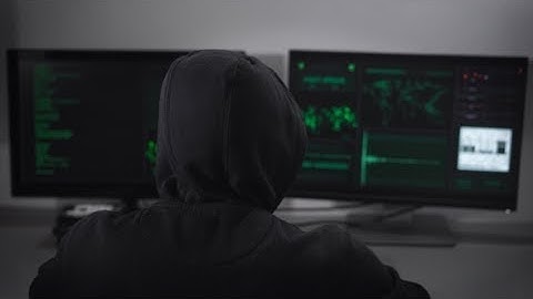 Rear View on the Hacker Who Is Engaged Clandestine Cyber Attacks (Stock Footage)