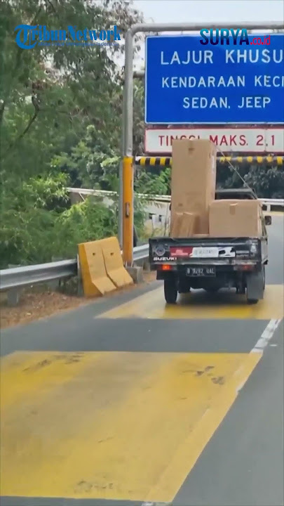 Sebuah Mobil Pickup Bermuatan Tinggi Terjebak Saat Ingin Lewat Jalur Khusus Kendaraan Kecil