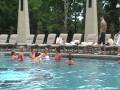 bride and bridesmaids jump in pool